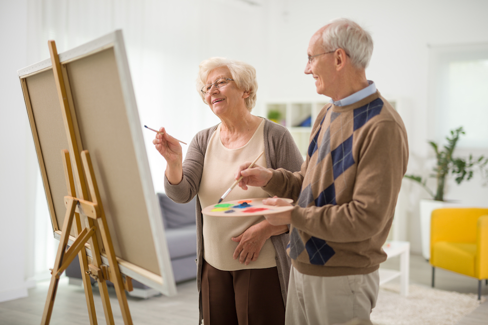 A senior couple taking a painting class