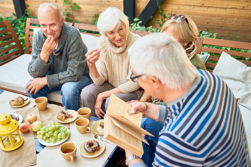 A group of senior friends enjoying a meal outdoors