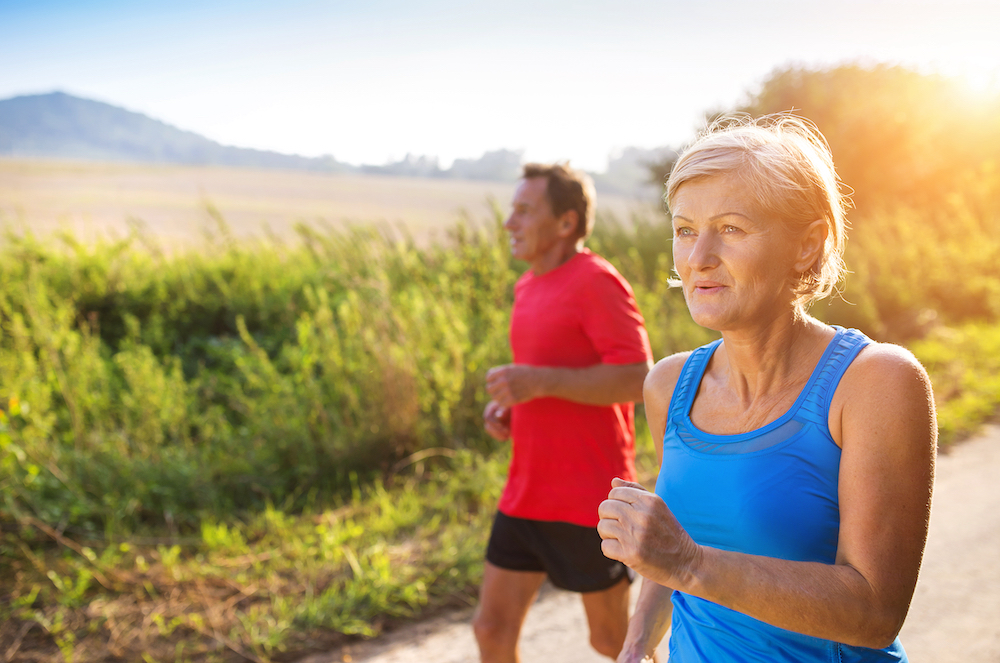 Two seniors go jogging outdoors