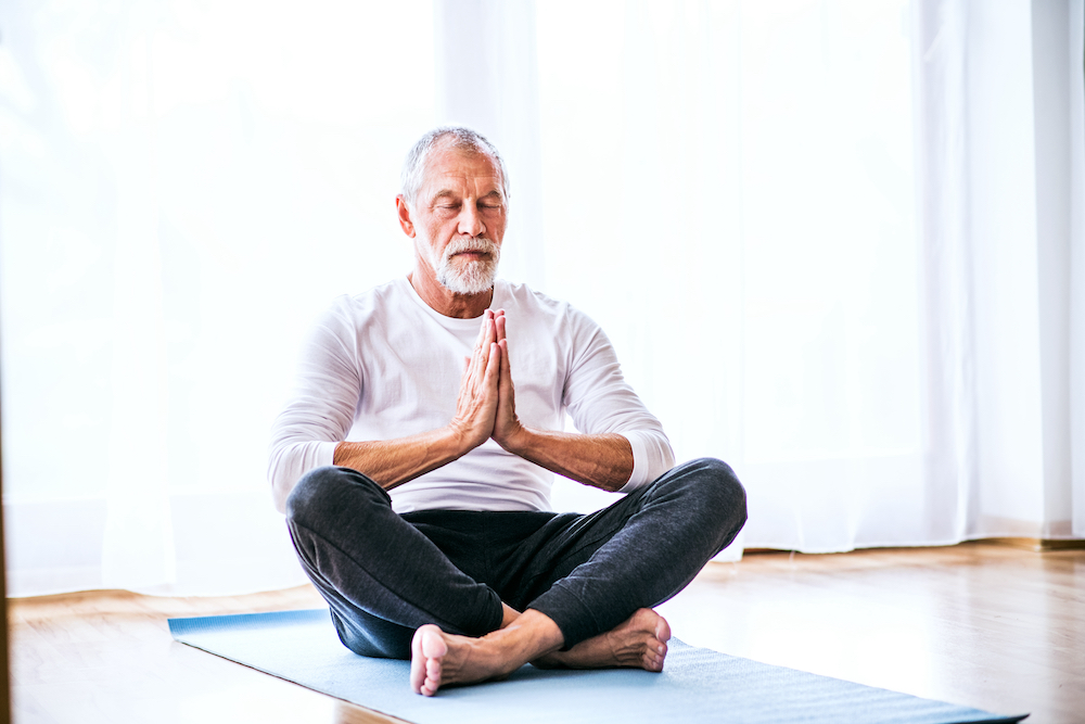 A senior man practices meditation 