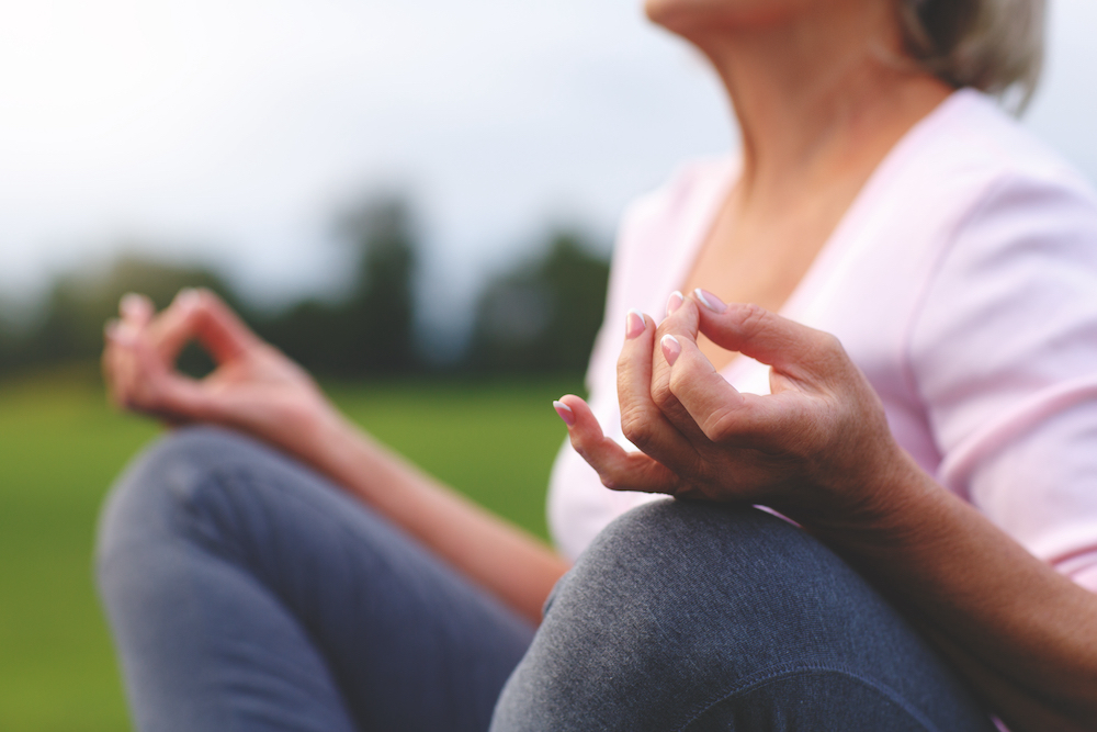 A senior woman meditating during yoga