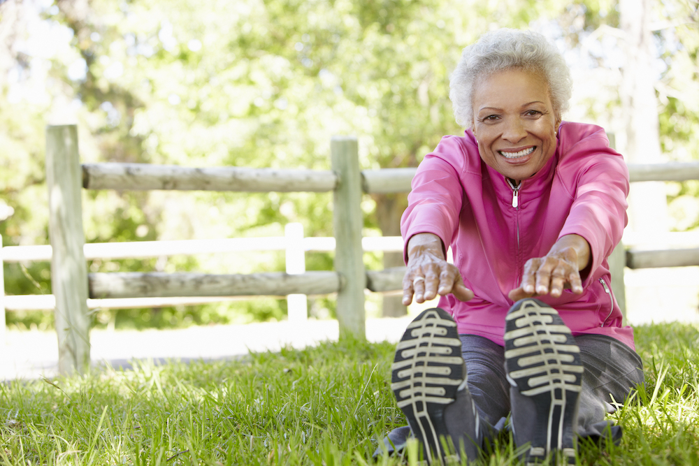 A senior woman stretching and doing toe touches