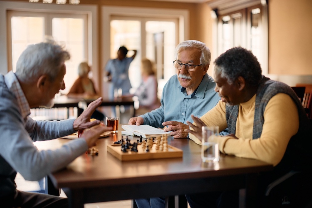 A group of men playing chess together at the Madison Heights senior apartments
