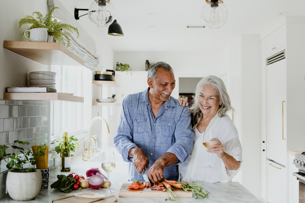 A happy senior couple cooking at the senior apartments in Madison Heights, MI