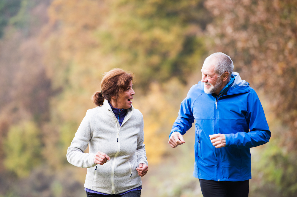 A happy, active senior couple out on a run together