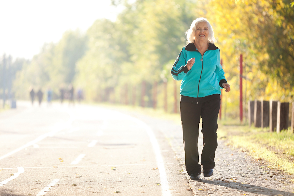 A healthy and smiling senior woman goes for a jog around her retirement community in Madison Heights, MII