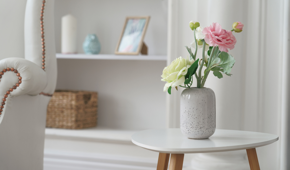 Fresh flowers in a vase sitting on a table in a modern, pretty apartment