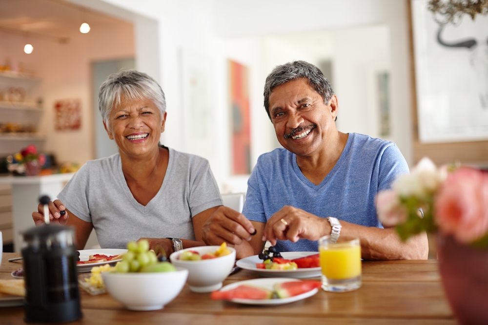 A happy older couple enjoying a healthy breakfast together at the senior apartments in Madison Heights, MI