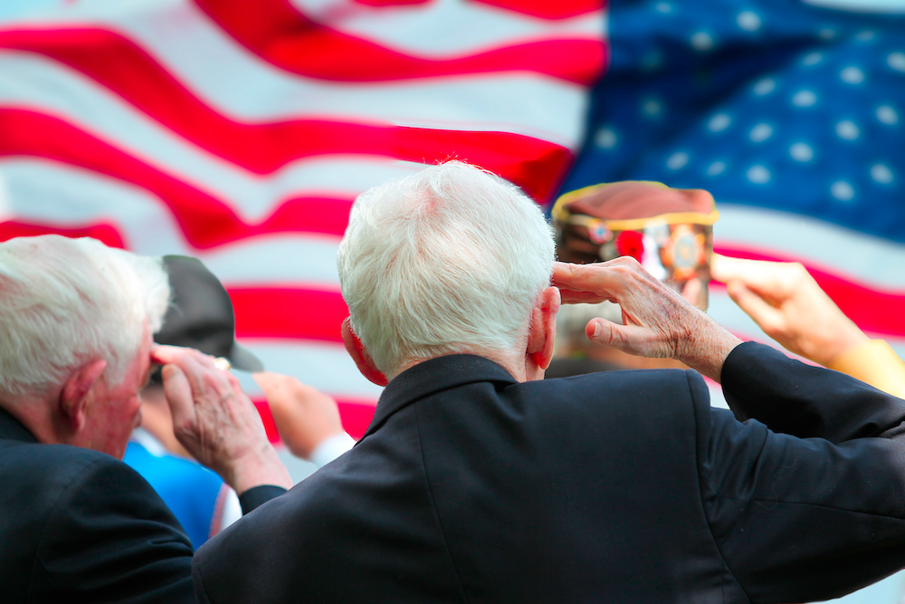 A group of senior veterans saluting the American flag