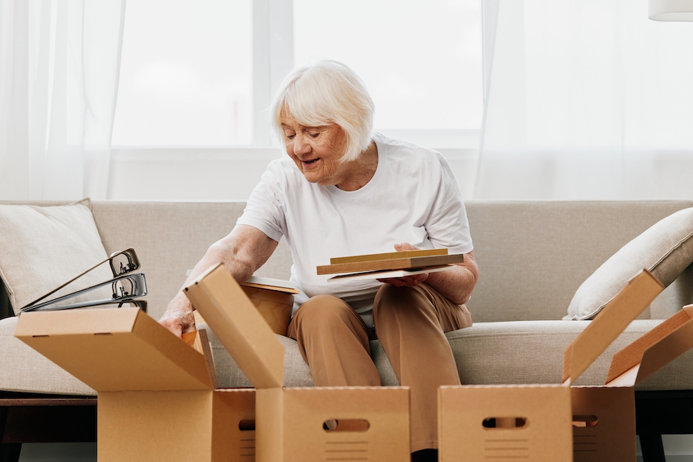 A senior woman packing up boxes to prepare to move to a senior living community