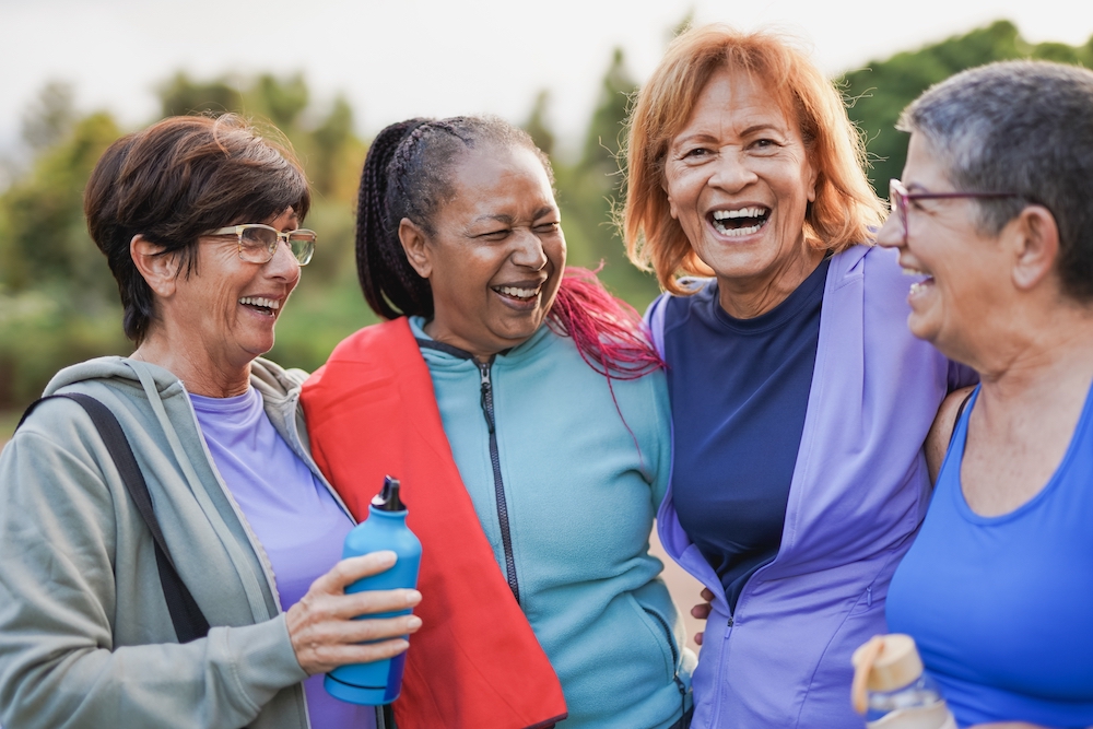 Four happy and active senior friends out on a walk together