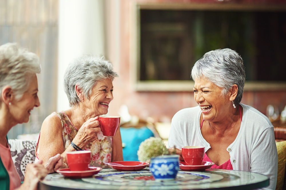 Three happy senior women having coffee
