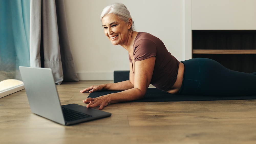 A resident of the senior independent living in Michigan using her computer to take an online yoga class