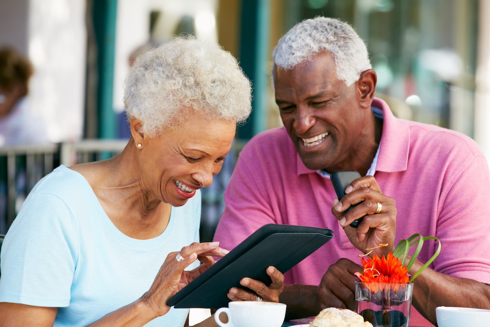A senior couple using a tablet to stay connected to their friends