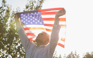 Veteran in luxury senior living holding American flag.