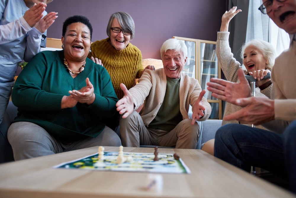 Group of seniors playing a board game together at senior care Troy MI