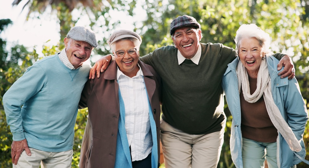 Group of seniors outside laughing and enjoying independent living for seniors