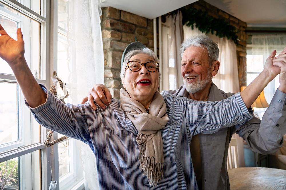 Senior couple inside happy and talking about independent senior living Michigan